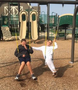 Henry and JR on swings at a playground