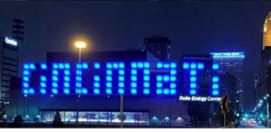 The word Cincinnati lit up in blue on the Duke Energy Center building